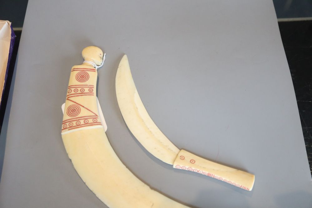 Two tribal carved warthog or boars tusk daggers, first half 20th century, picked out in red pigment